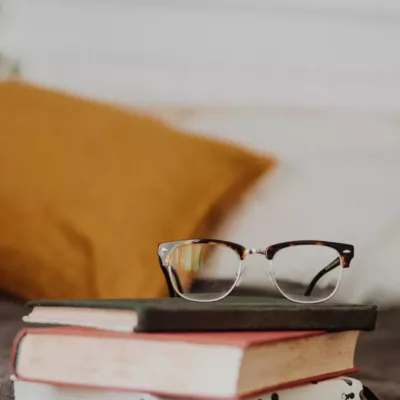 club master eyeglasses on pile of three books